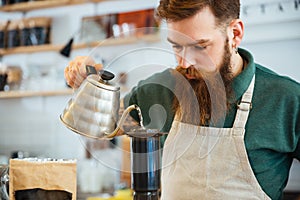 Barista pouring water on coffee ground with filter