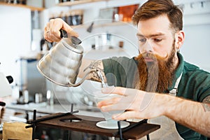 Barista pouring water on coffee ground with filter