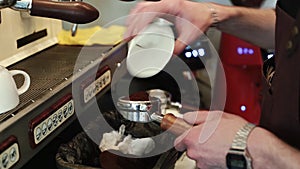 Barista pours freshly ground coffee into the Holder in order to prepare an espresso.