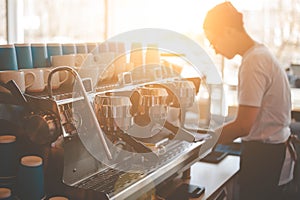 Barista prepares coffee in a Sunny cafe.