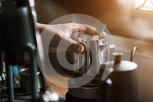 Barista preparing coffee using coffee maker and drip kettle. Man making coffee. Alternative ways of brewing coffee. Coffee shop,