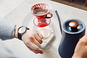 Barista Preparing Specialty Coffee Using V60 Pour-Over Method While Monitoring Time photo