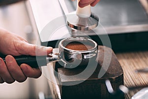 Barista pressing coffee in the machine holder