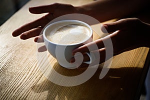 Barista propose americano or espresso coffee cup. fresh morning coffee with milk and cream froth. Good start of the