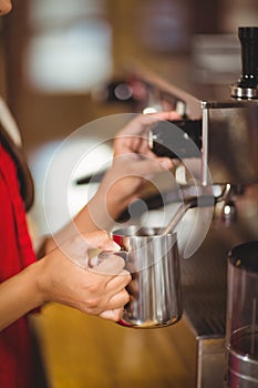 Barista steaming milk at the coffee machine