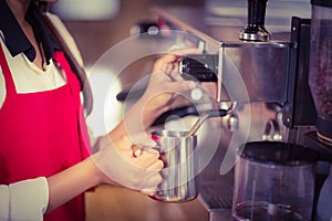 Barista steaming milk at the coffee machine