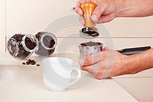 Barista tamp ground coffee with tamper on table