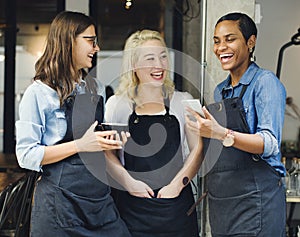 Baristas watching something funny on a phone