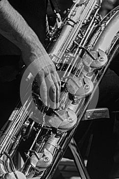 Baritone saxophone player. Hands and instrument details