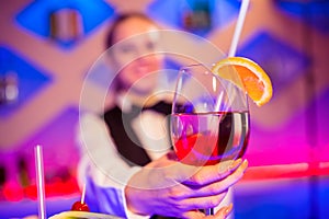 Barmaid holding cocktail glass