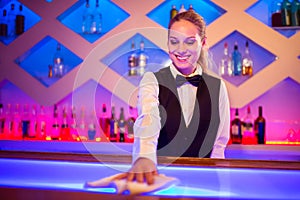 Barmaid smiling cleaning bar counter