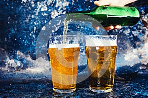 Barman with beer bottle pouring a draught lager beer