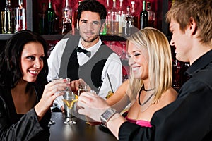 Barman behind counter friends drinking at bar photo