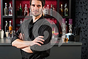 Barman in black standing at cocktail bar photo