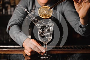 Barman decorating a cocktail glass with splashing drink