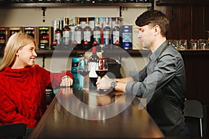 Barman and girl-visitor drink and talk about wine