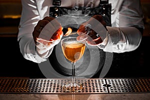 Barman hands making a fresh alcoholic drink with a smoky note