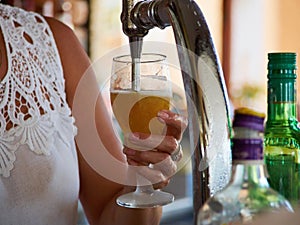 Barman hands pouring draught beerfrom a tap