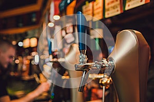 Barman hands pouring a lager beer in a glass.