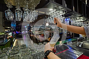 Barman hands pouring a lager beer in a glass