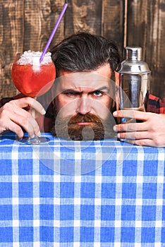 Barman or hipster holds cocktail with ice and straw.