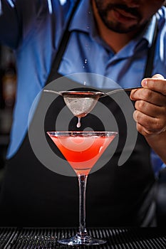 Barman makes cosmopolitan cocktail