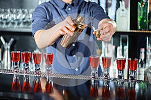 Barman makes shots in a bar