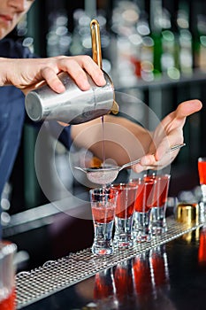 Barman makes shots in a bar