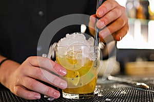 Barman is making cocktail at night club