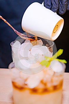 Barman making a coffee cocktail and a mojito photo