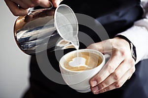 Barman making coffee, pouring milk