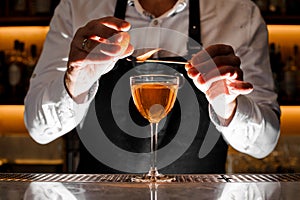 Barman making a fresh alcoholic cocktail with smoky note