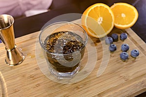 Barman mixes alcohol cocktail on the rocks. Hands close-up.