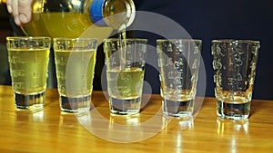 Barman pouring alcohol to the five shots