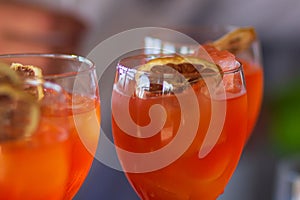 Barman pouring a fresh pink alcoholic cocktail into the elegant glass on the bar counter