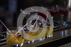 Barman pouring a fresh pink alcoholic cocktail into the elegant glass on the bar counter