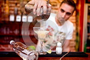 Barman pouring a margarita alcoholic cocktail serv