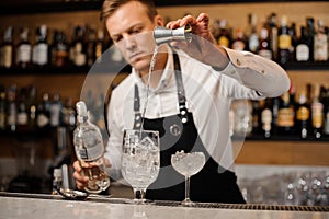 Barman pouring a portion of vodka into a glass