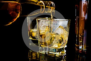 Barman pouring whiskey in front of whiskey glass and bottles