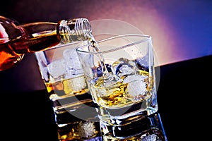 Barman pouring whiskey in front of whiskey glass on light tint blue disco