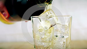 Barman pouring whiskey in the glass with ice cubes on wood table background, focus on ice cubes, whisky relax time, gold warm