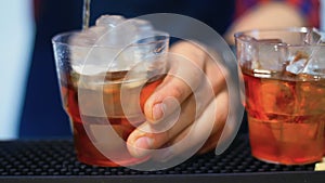 Barman preparing cocktail at bar. Bartender stirring alcoholic drink with ice