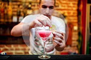 Barman preparing cosmopolitan alcoholic cocktail drink at bar