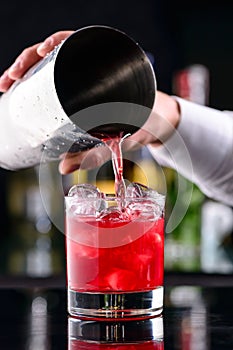 Barman preparing strawberry daiquiri cocktail.