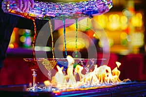 Barman show. Bartender pours alcoholic colorful cocktails.