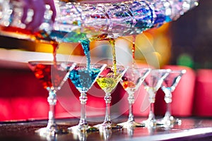 Barman show. Bartender pours alcoholic colorful cocktails.