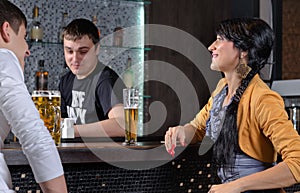 Barman socialising with customers at the bar