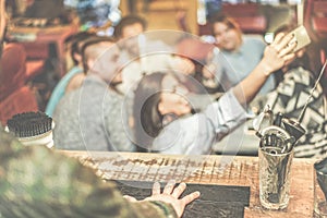 Barman view of happy friends taking selfie with mobile smart phone in cocktail pub bar - Young people having fun together with