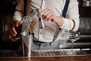 Barman in white shirt making alcohol coctail no face