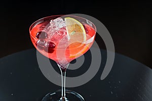 Barman at work, preparing cocktails. pouring cosmopolitan to cocktail glass.